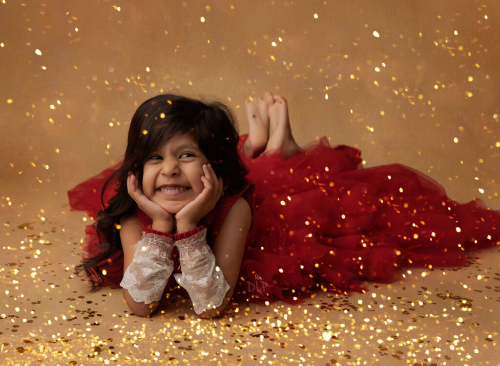 Experience Austin Baby Photography younf girl in red dress with gold glitter around her