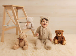 Austin Baby Photographer boy in bear outfit sitting with teddy bears