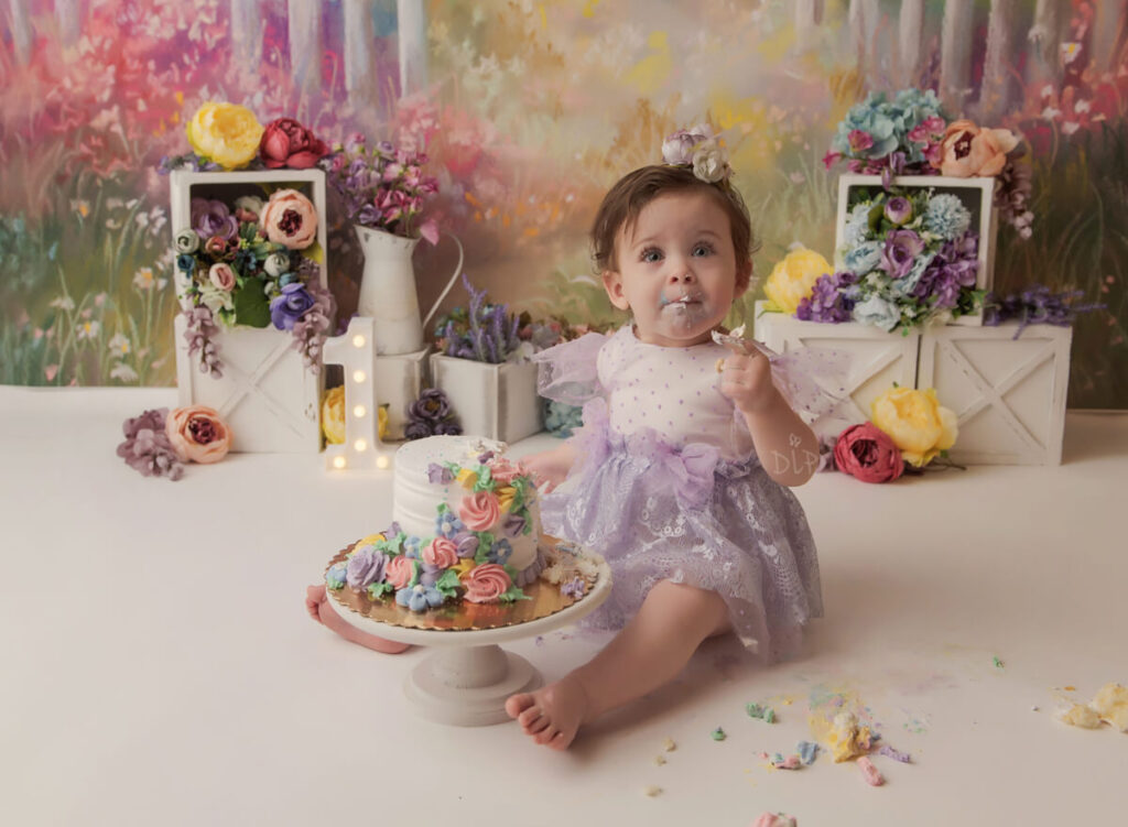 Experience Austin Baby Photography one year old girl in purple dress eating cake