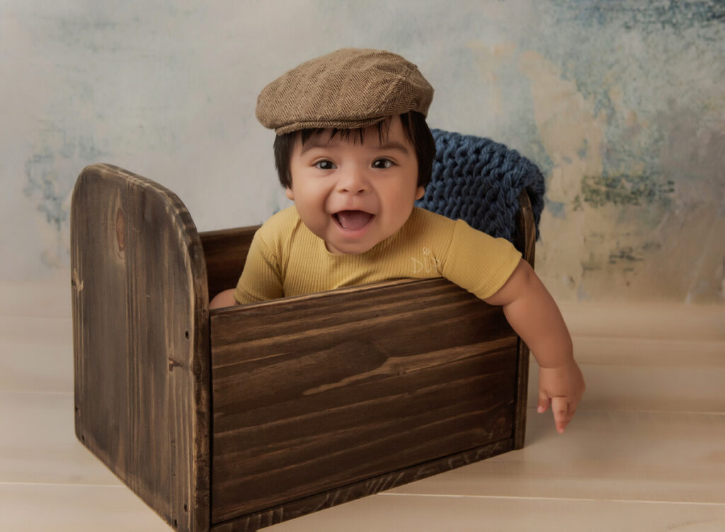 Austin Baby Photographer boy in yellow outfit and hat sitting in bed