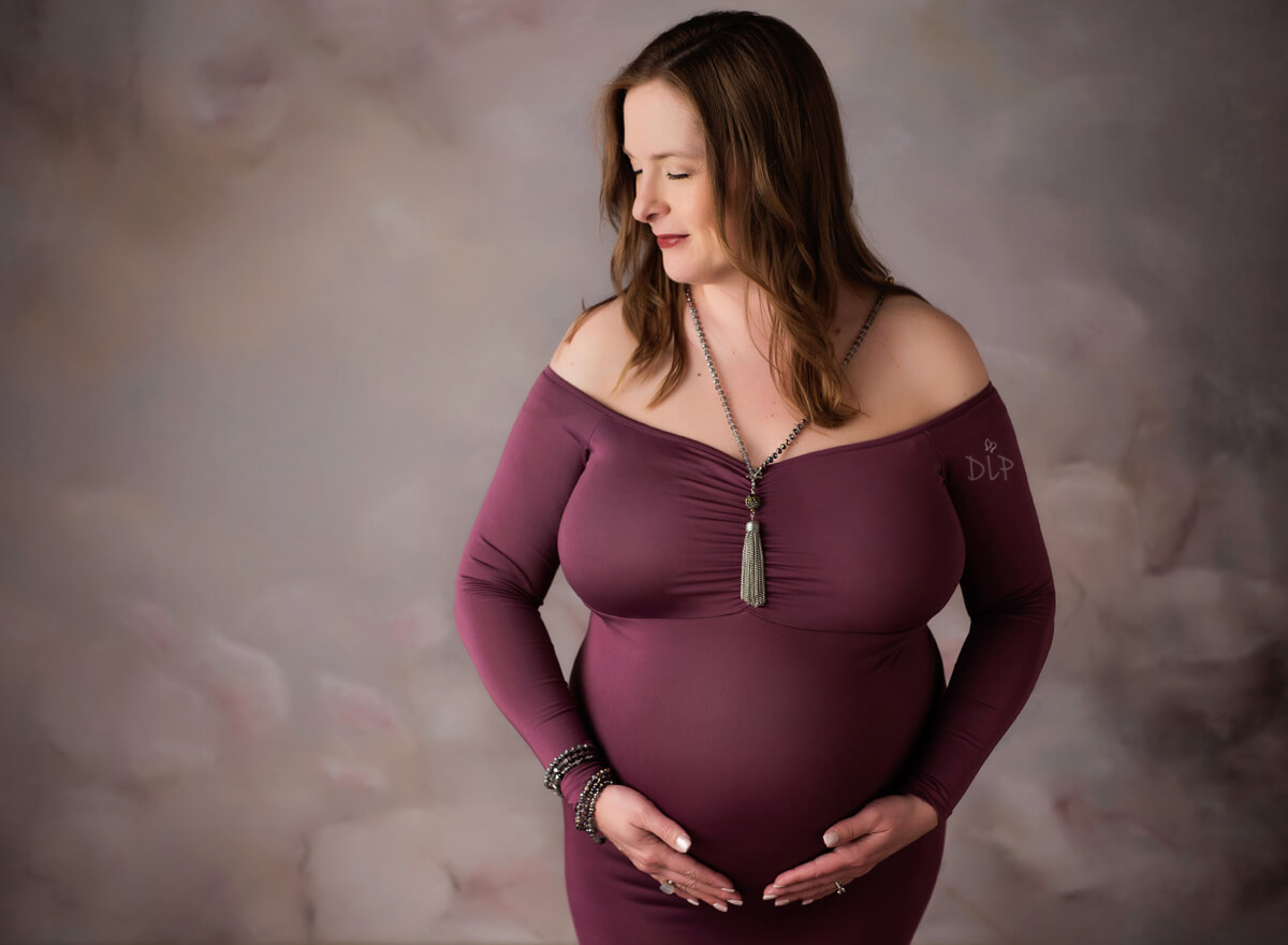 Austin Maternity Photographer expecting mom posing in purple gown