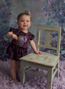 Austin Baby Photographer girl in purple outfit holding flower
