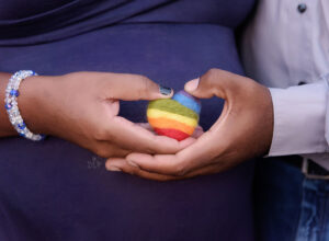 Austin Maternity Photographer expecting mom and dad holding rainbow heart