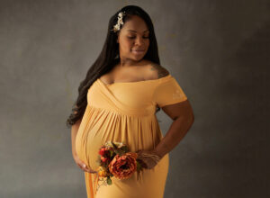 Austin Prenatal Massage expecting mama posing in yellow dress with flowers