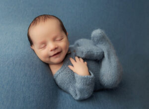 Austin Newborn Photographer baby boy smiling in blue outfit