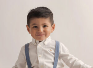 Experience Austin Baby Photography young boy in white shirt with blue suspenders