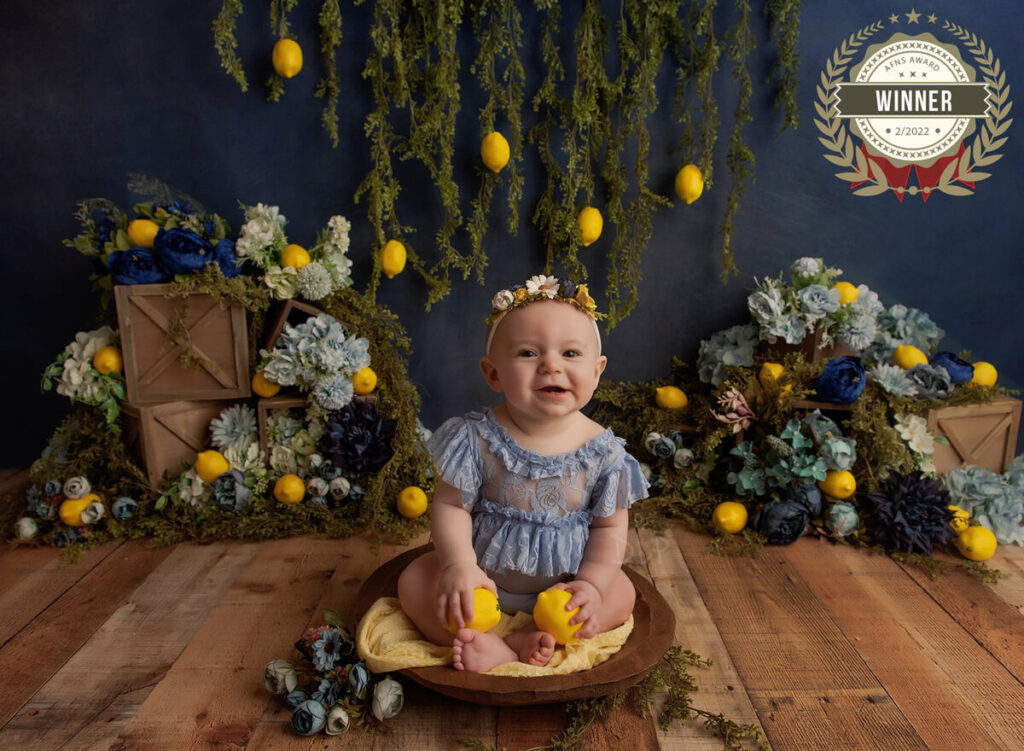 Austin Baby Photographer girl wearing blue dress sitting in bowl with lemons and flowers