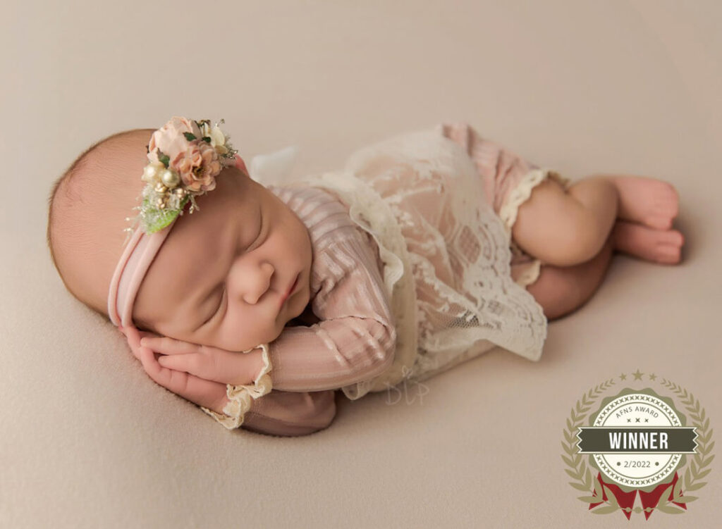 Austin Newborn Photographer baby girl in pink outfit on cream fabric