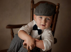 Experience Austin Baby Photography young boy in vintage clothing sitting in chair.